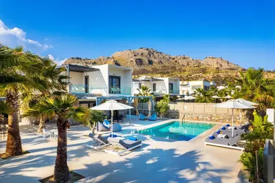 a villa with a swimming pool and palm trees at Lindian Palms in Lardos