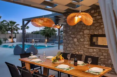 a dining room with a table and chairs and a pool at Lindian Palms in Lardos