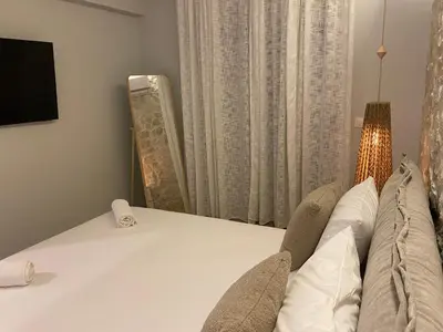 a bedroom with a bed and a tv and a window at Villa Massari in Haraki