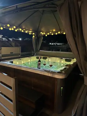 a jacuzzi tub with two glasses of wine at Villa Massari in Haraki