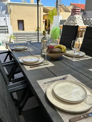 a wooden table with plates and wine glasses on it at Villa Massari in Haraki