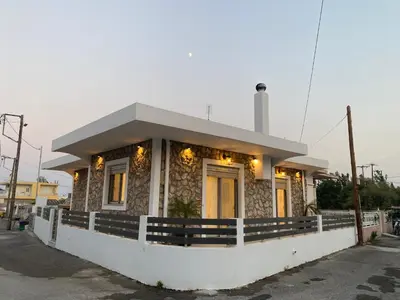 a small house with lights on the front of it at Villa Massari in Haraki