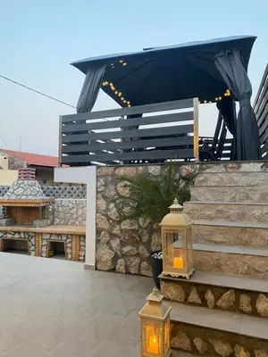 a patio with stairs and a black canopy and a lantern at Villa Massari in Haraki