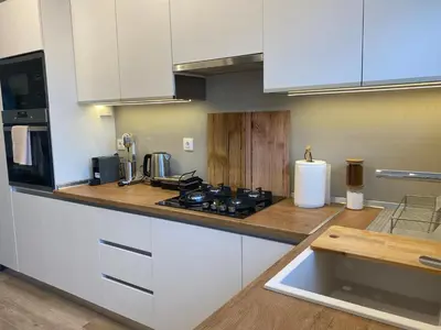 a kitchen with white cabinets and a stove top oven at Villa Massari in Haraki