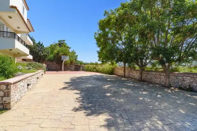 a brick driveway with a tree and a basketball hoop at Villa Amarandes With Private Pool in Paradeísion