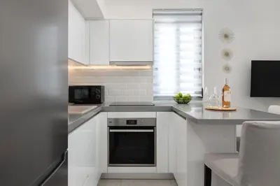 a kitchen with white cabinets and a black oven at Rhodes city studios in Rhodes Town