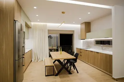 a kitchen with a wooden table and a dining room at Ikia Seascape At Stegna in Archangelos
