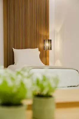 a bedroom with a bed and a lamp and plants at Ikia Seascape At Stegna in Archangelos