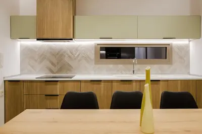 a kitchen with a table with chairs and a microwave at Ikia Seascape At Stegna in Archangelos