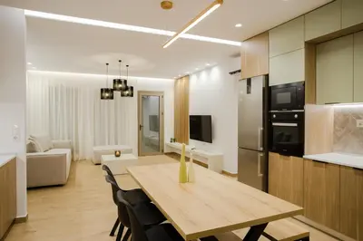 a kitchen and living room with a wooden table and chairs at Ikia Seascape At Stegna in Archangelos