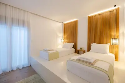 a bedroom with two beds and a window at Ikia Seascape At Stegna in Archangelos