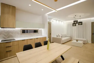 a kitchen and living room with a table and a couch at Ikia Seascape At Stegna in Archangelos