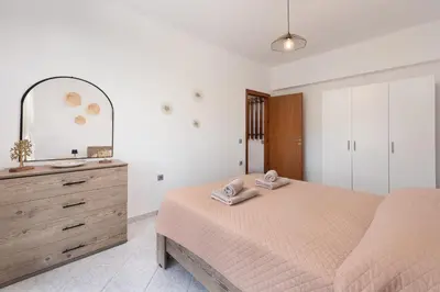 a bedroom with a bed and a dresser and a mirror at Afandou Panorama Apartment in Afantou