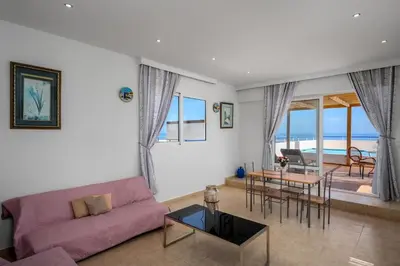 a living room with a purple couch and a table at Stegna Sunrise Suite Sleeps 4 Pool in Archangelos