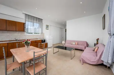 a kitchen and a living room with a table and a couch at Stegna Sunrise Suite Sleeps 4 Pool in Archangelos