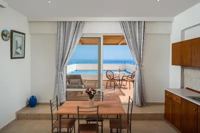 a kitchen and dining room with a view of the ocean at Stegna Sunrise Suite Sleeps 4 Pool in Archangelos