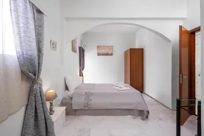 a bedroom with a bed in a white room at Stegna Sunrise Suite Sleeps 4 Pool in Archangelos