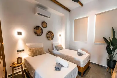 a room with two beds and a clock on the wall at CasaCarma III, private pool, boho design, central in Lachania