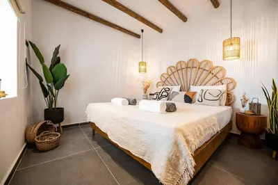 a bedroom with a large bed in a room with plants at CasaCarma III, private pool, boho design, central in Lachania
