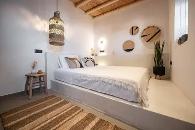 a bedroom with a bed in a white room at CasaCarma II, private pool, boho design, tradition in Lachania