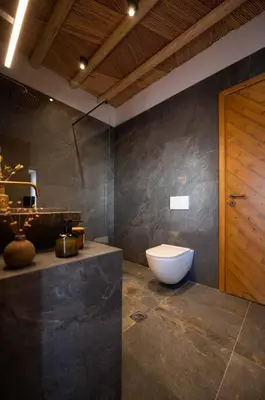 a bathroom with a toilet in the corner of a room at CasaCarma II, private pool, boho design, tradition in Lachania