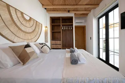 a large white bed in a room with windows at CasaCarma II, private pool, boho design, tradition in Lachania