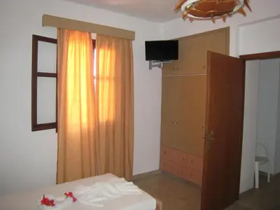 a bedroom with a bed and a dresser and a window at Eleftheria Lindian Studios I in Líndos