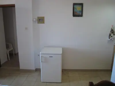 a small white refrigerator sitting in a room at Eleftheria Lindian Studios I in Líndos