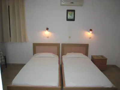 two beds in a room with lights on the wall at Eleftheria Lindian Studios I in Líndos