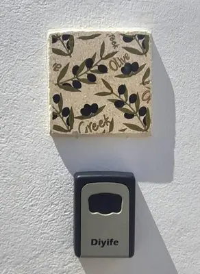 a digital clock on a white wall with a plug at The Olive Tree Villa Lindos in Líndos