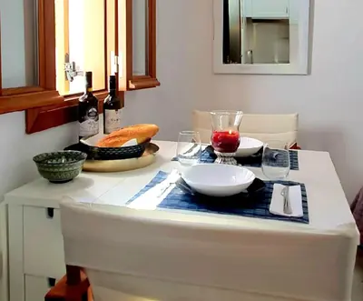 a table with glasses of wine and bread on it at The Olive Tree Villa Lindos in Líndos