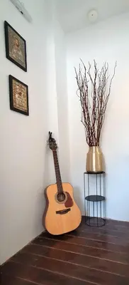 a guitar leaning against a wall next to a vase at The Olive Tree Villa Lindos in Líndos