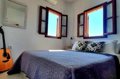 a bedroom with a bed and a guitar in it at The Olive Tree Villa Lindos in Líndos