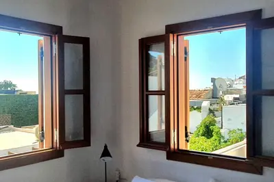 two windows in a room with a view of a city at The Olive Tree Villa Lindos in Líndos