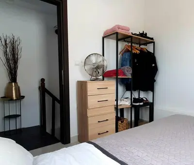 a bedroom with a bed and a wooden dresser at The Olive Tree Villa Lindos in Líndos