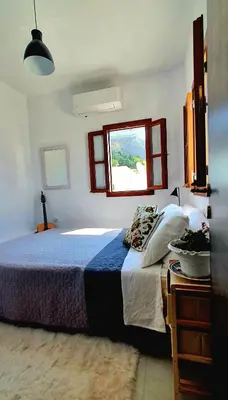 a bedroom with a large bed and a window at The Olive Tree Villa Lindos in Líndos