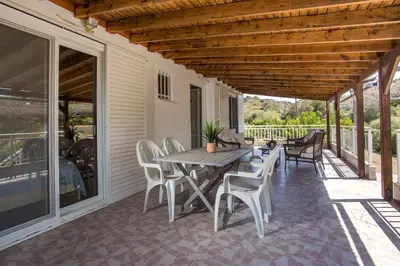 a patio with a table and chairs on it at Villa Hercules in Kremasti