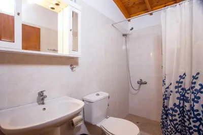 a bathroom with a toilet and a sink and a shower at Villa Hercules in Kremasti