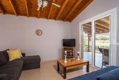 a living room with a couch and a table at Villa Hercules in Kremasti
