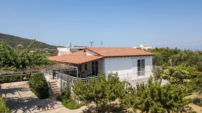 a small white house with a red roof at Villa Hercules in Kremasti