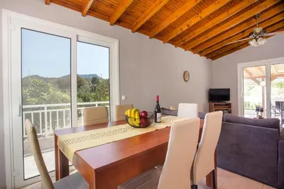 a dining room with a table and a couch at Villa Hercules in Kremasti