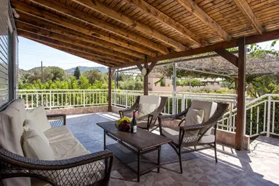 a patio with wicker chairs and a table at Villa Hercules in Kremasti