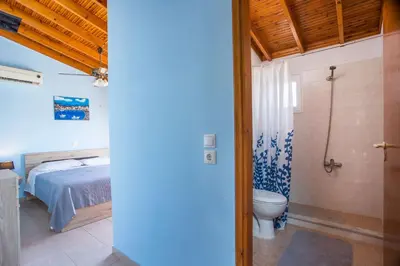a bedroom with a bed and a bathroom with a toilet at Villa Hercules in Kremasti