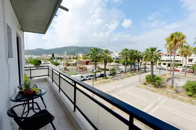 a balcony with a table and a view of a city at Palm Square Appart in Ialyssos
