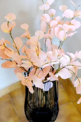 a black vase with pink flowers in it at Palm Square Appart in Ialyssos