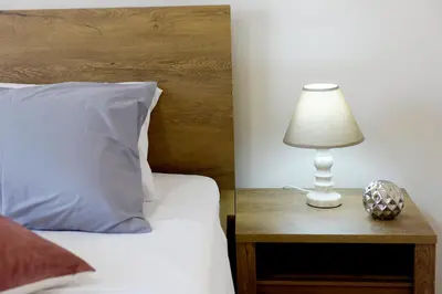 a lamp on a table next to a bed at Palm Square Appart in Ialyssos