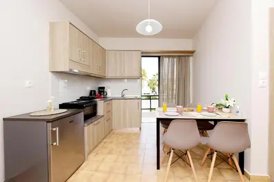 a kitchen with a table and two chairs in it at Palm Square Appart in Ialyssos