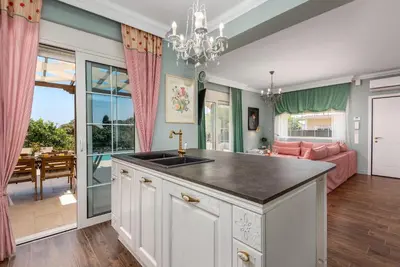 a kitchen with a sink and a living room at Cypress View Boutique Villa in Asgourou