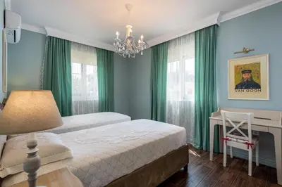 a bedroom with green curtains and a bed and a desk at Cypress View Boutique Villa in Asgourou