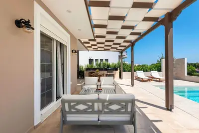 a patio with a couch and a pool at Cypress View Boutique Villa in Asgourou